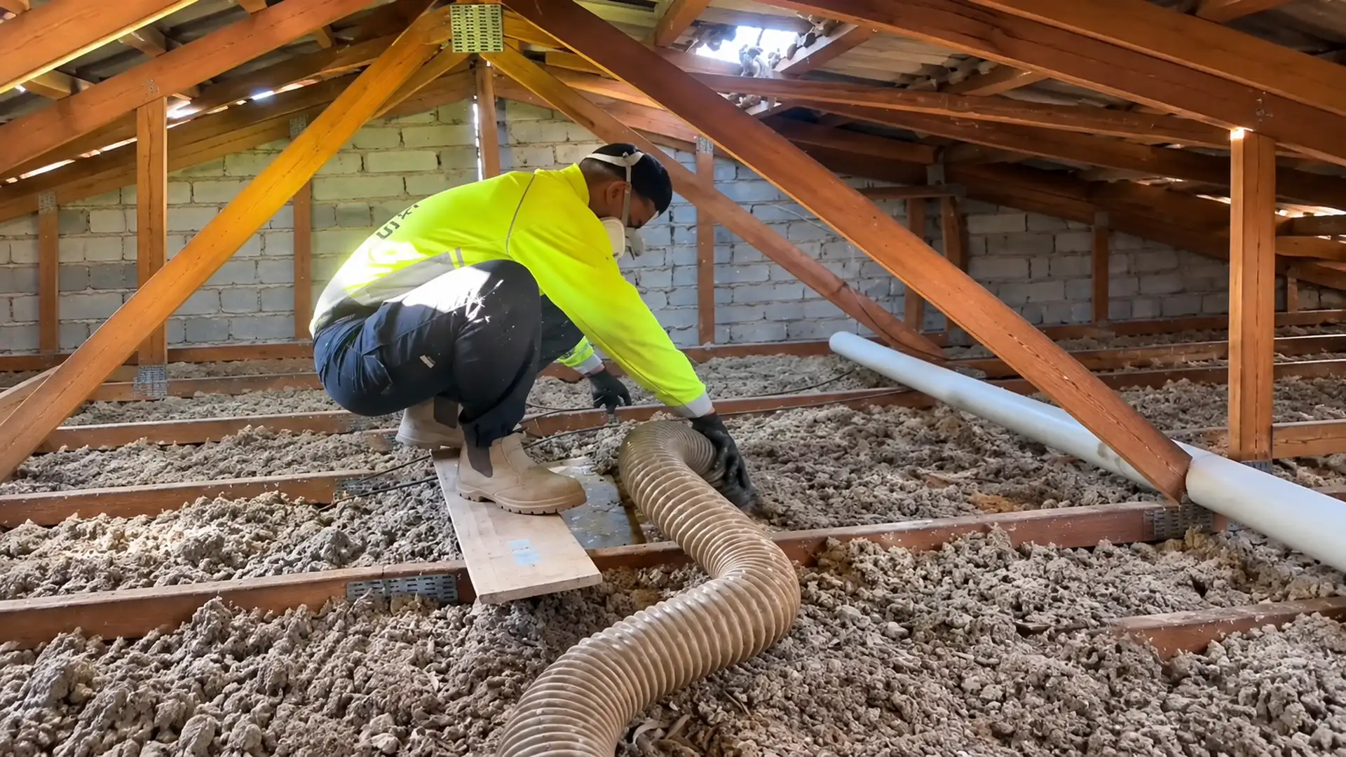Installer laying insulation in a Canberra roof space