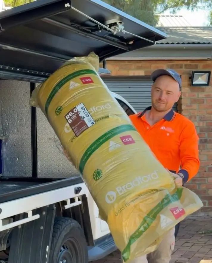 Dom carrying a roll of insulation batts